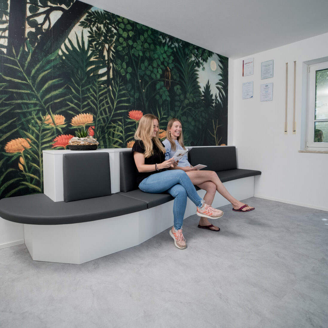 2 Damen sitzen im Wartebereich der Praxis